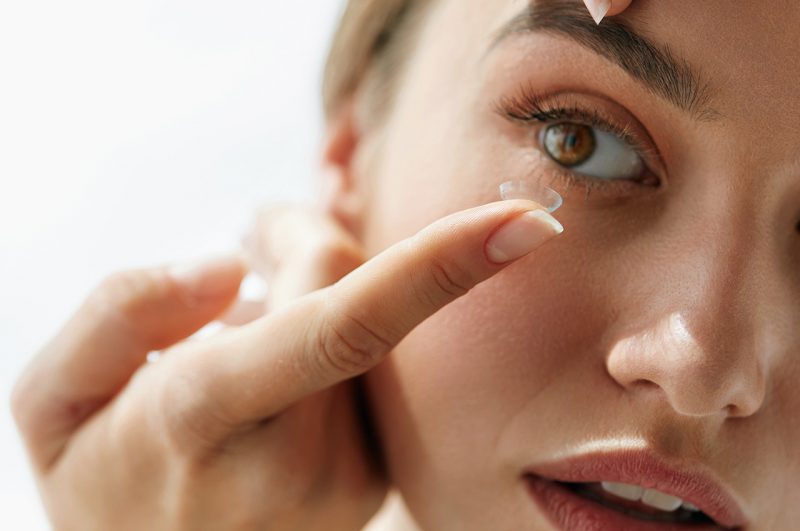 Vision Contact Lenses. Closeup With Beautiful Woman Face